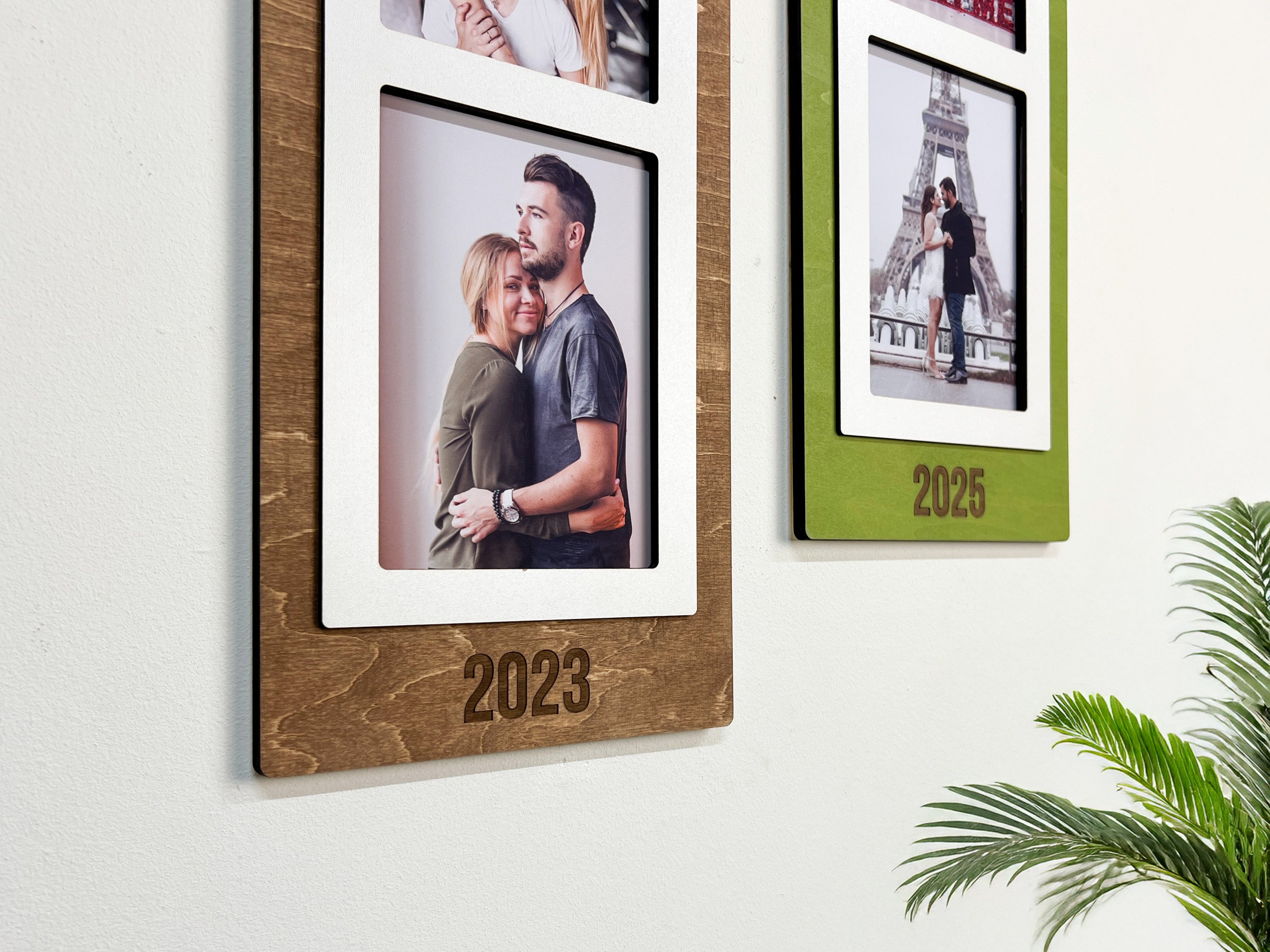 Handcrafted wooden picture frames with years 2023 and 2025, displaying couple photos on a white wall.