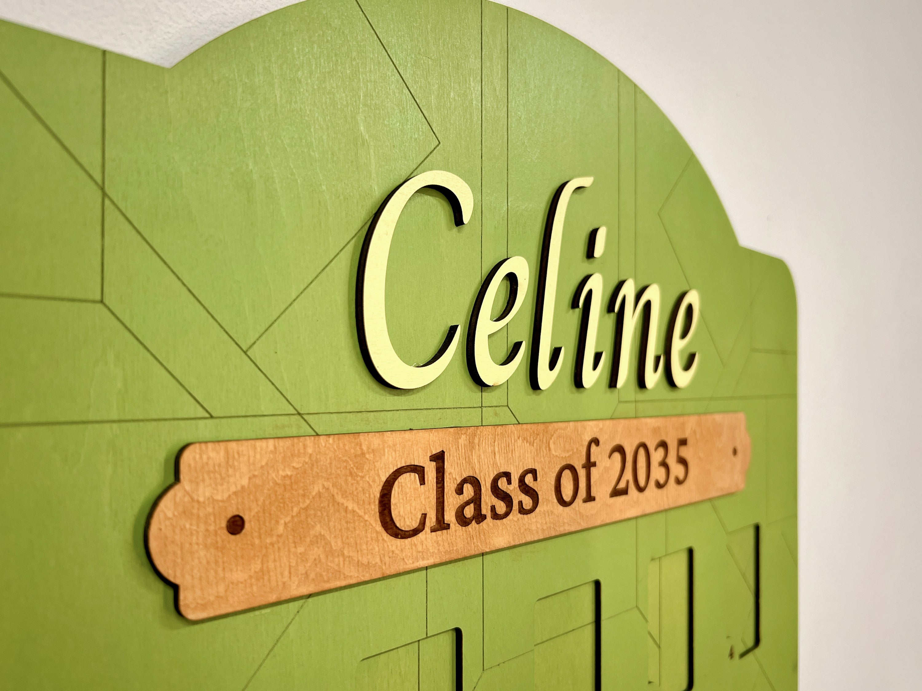 Personalized green wooden picture frame with 'Celine Class of 2035' engraved plaque.