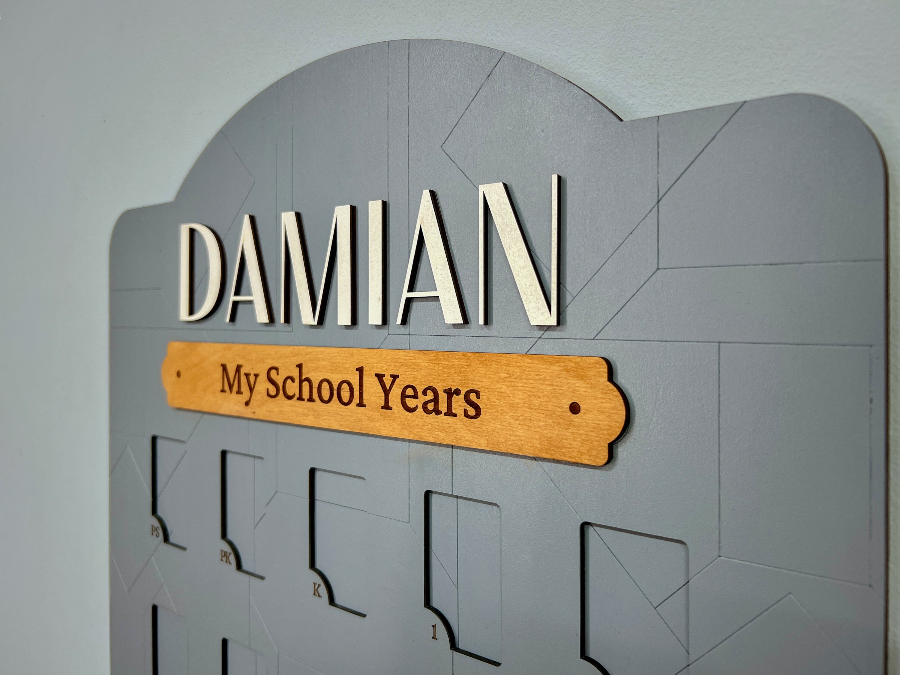 Gray wooden school years photo frame with 'DAMIAN My School Years' engraved, wall-mounted.