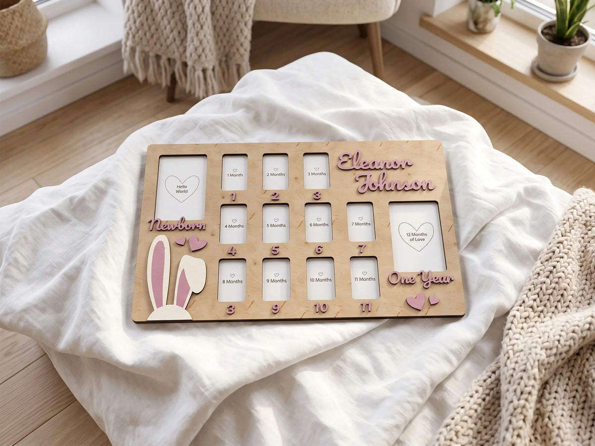 Personalized wooden baby first year photo frame by The Frame Depot on a white blanket.