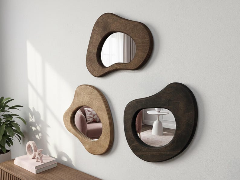 Set of three organic pebble mirrors with handcrafted wood frames styled as modern wall decor
