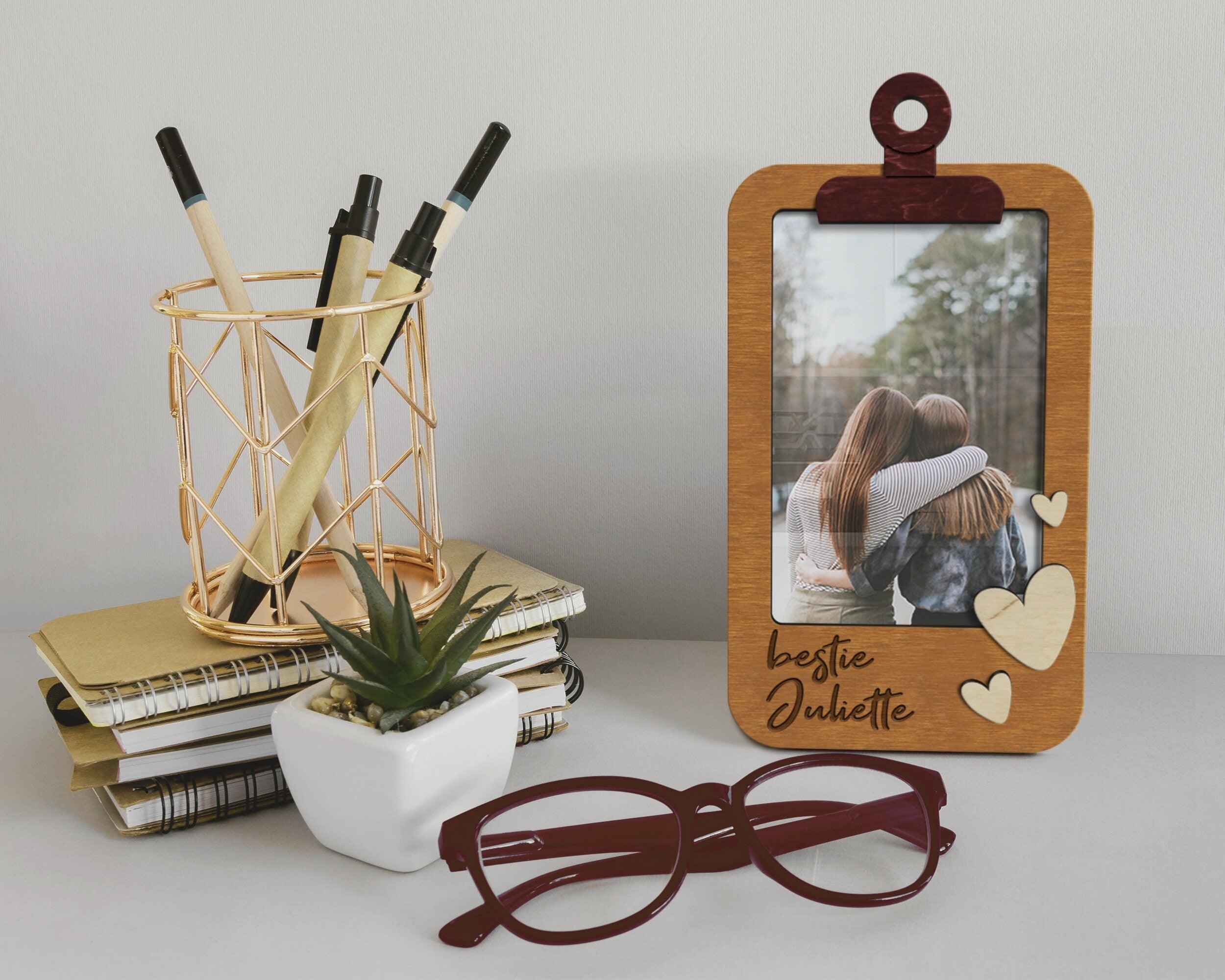 Wooden 4 by 6 inches photo frame shaped as a clipboard with a text on the bottom left and 3 hearts on the bottom right. The text is - bestie Juliette. This frame is 9 by 5 inches. The frame can be painted in different colors. The name can be changed.